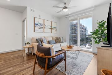 St. George apartment for rent - A living room with a white couch, a wooden chair, and a painting on the wall.