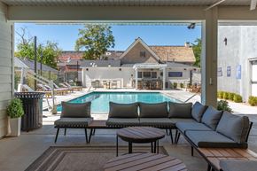 St. George apartment for rent - a swimming pool is seen from a patio with couches and tables at City View St. George Apartments, Utah, 84770