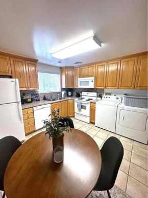 Orem apartment for rent - A kitchen with a table and chairs in the middle.