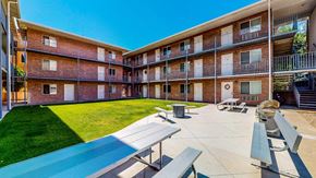 Provo apartment for rent - A sunny day at the apartment complex with blue skies and green grass.