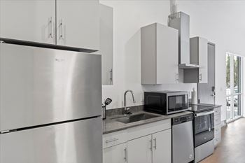 A modern kitchen with stainless steel appliances and white cabinets.