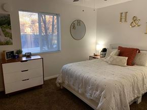 Provo apartment for rent - A bedroom with a bed, nightstand, and a window with blinds.