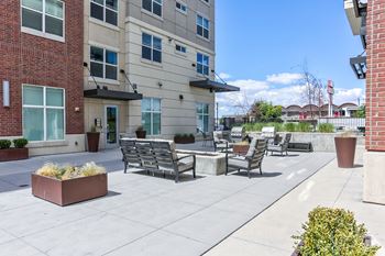 Patio area with chairs and planters in front of a building