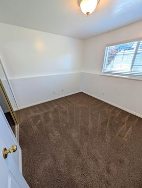 Orem apartment for rent - A room with a carpeted floor and a door on the left side.