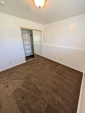 Orem apartment for rent - A room with a brown carpet and a white wall.