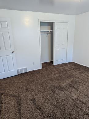 Orem apartment for rent - A room with a carpeted floor and a closet with a door open.