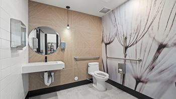 A bathroom with a toilet, sink, and mirror.