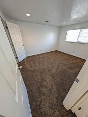 Orem apartment for rent - A room with a carpeted floor and a window with blinds.