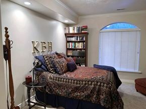 Provo apartment for rent - A bedroom with a bed, a bookshelf, and a floor lamp.