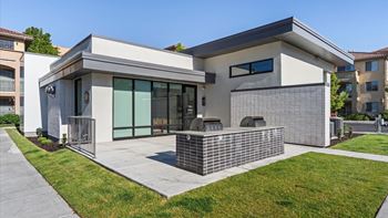 A modern house with a grey and white exterior and a brick wall.