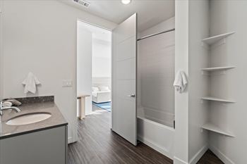 A bathroom with a sink, mirror, and towel rack.