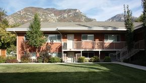Provo apartment for rent - A red brick building with a mountain in the background.