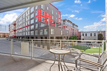 A red and grey building with a table and chairs in front.