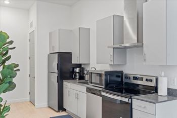 A modern kitchen with a black refrigerator and stove.