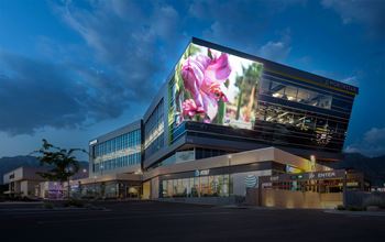 A modern building with a large screen displaying a flower on it.