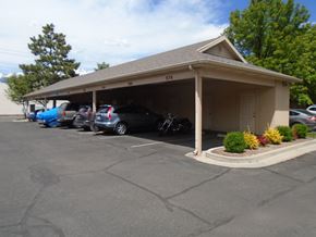 Orem apartment for rent - A parking lot with a building and cars parked.