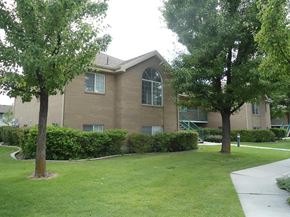 Orem apartment for rent - A building with a green lawn in front.