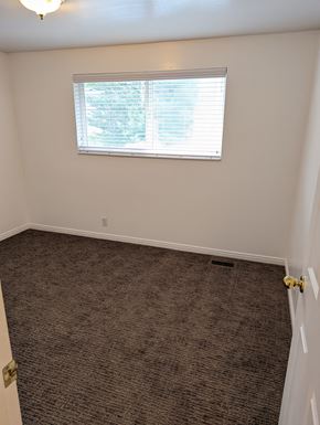 Orem apartment for rent - A room with a carpeted floor and a window with blinds.
