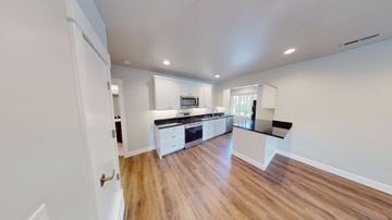 Provo apartment for rent - A kitchen with white cabinets and a wooden floor.
