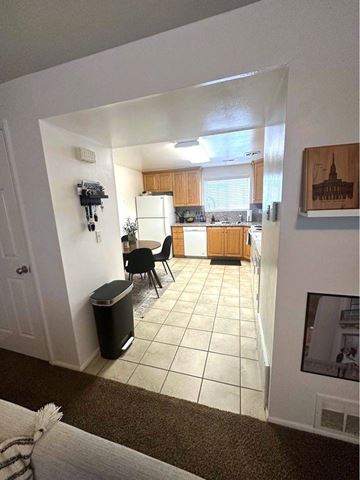 Orem apartment for rent - A kitchen with a dining table and chairs is visible from the living room.