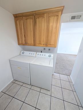Orem apartment for rent - A white dishwasher is in a kitchen with wooden cabinets.