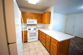 Provo apartment for rent - A kitchen with wooden cabinets and a white countertop.