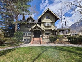 Provo apartment for rent - A large house with a triangular roof and a stone wall.