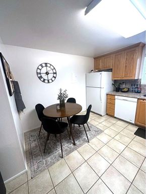 Orem apartment for rent - A kitchen with a table and chairs and a clock on the wall.