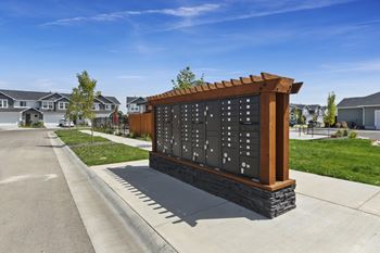 A wooden and black sign with numbers is in the foreground of a residential street.