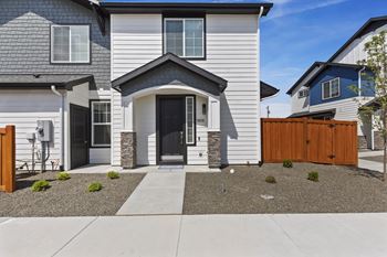 A modern house with a grey front and a black door.