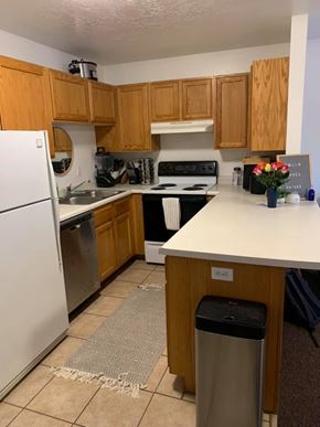 Provo apartment for rent - A kitchen with wooden cabinets and a white refrigerator.