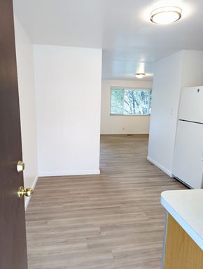 Orem apartment for rent - A kitchen with a white fridge and wooden floors.