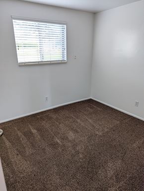 Orem apartment for rent - A room with a carpeted floor and a window with blinds.