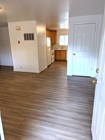 Orem apartment for rent - A kitchen with a white door and wooden floors.