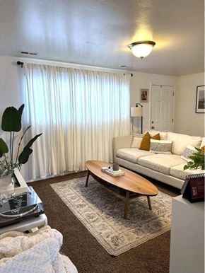 Orem apartment for rent - A living room with a couch, a coffee table, and a rug.