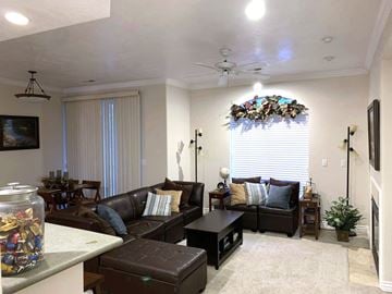 Provo apartment for rent - A living room with a brown couch and a glass jar filled with colorful beads on the coffee table.