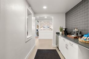 Vancouver apartment for rent - a kitchen with white cabinets and a counter top and a door to a store at AVIA Lofts on Parkway Apartments, Vancouver, 98662