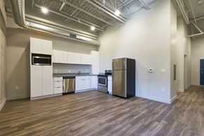 Millcreek apartment for rent - A kitchen with white cabinets and a black refrigerator at Brickside Heights Apartments, Utah, 84106