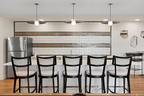 Salt Lake City apartment for rent - a kitchen with a long table with chairs and a refrigerator at The Revival, Salt Lake City, UT