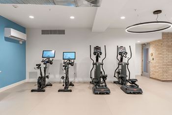 A room with exercise bikes and a blue wall.