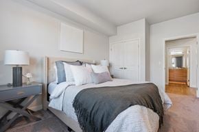 Provo apartment for rent - a bedroom with a large bed and a door to a bathroom at The Flats at Riverwoods, Provo, Utah
