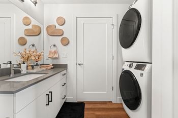 Combination bathroom and laundry room with stacked washer dryer