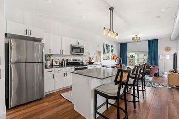 Open kitchen with white island and bar seating