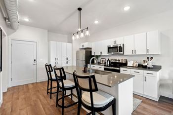 White kitchen with island and black bar stools