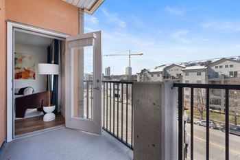 Balcony with open door and view of street below