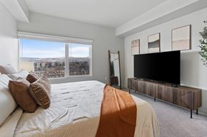 Salt Lake City apartment for rent - A bedroom with a large bed and a television at Wilmington Flats Apartments, Utah