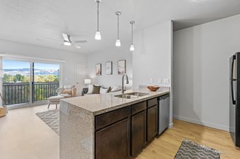 A kitchen with a marble countertop and a refrigerator on the right.