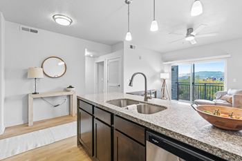 A modern kitchen with a large island and a view of the city.
