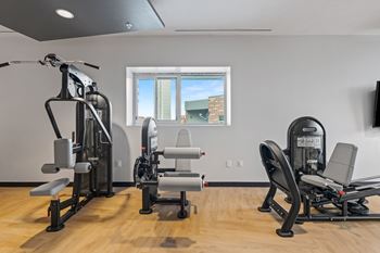 A gym with a rowing machine, a leg press machine, and a chest press machine.