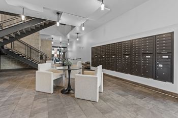 A room with a table and chairs and a wall of lockers.